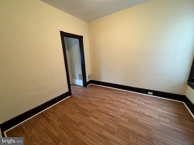 spare room with wood finished floors and baseboards