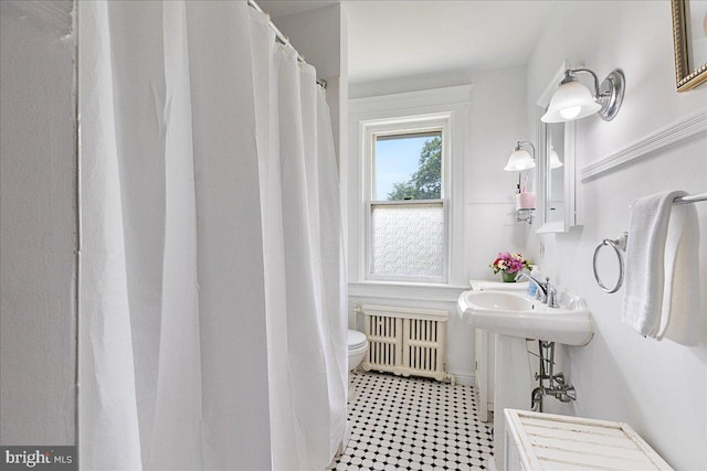 bathroom featuring radiator heating unit and toilet