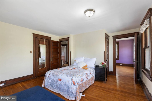 bedroom with baseboards and wood finished floors