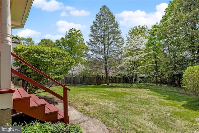 view of yard featuring fence and stairway