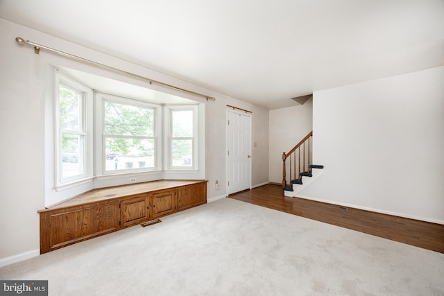 carpeted foyer entrance with stairs and baseboards