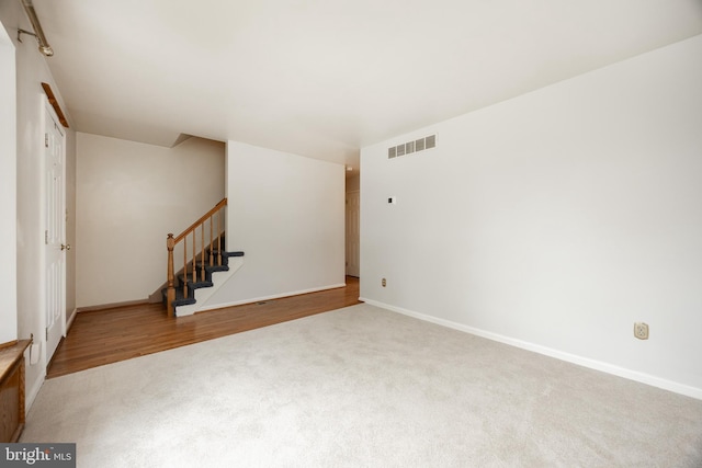 unfurnished room with carpet flooring, stairway, and baseboards