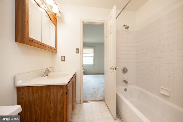 bathroom with washtub / shower combination, toilet, vanity, and tile patterned floors