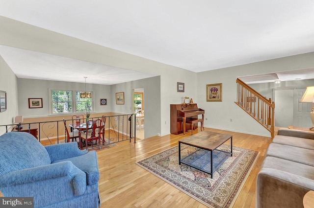 79 Wolfpack Rd, Hamilton, NJ 08619 - living room featuring light wood-type flooring, stairs, and a notable chandelier