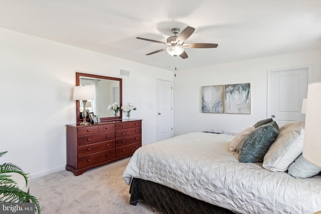 bedroom with visible vents, a ceiling fan, baseboards, and light carpet