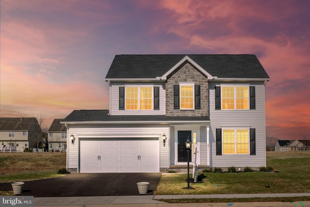 traditional home featuring a front lawn, driveway, an attached garage, and roof with shingles