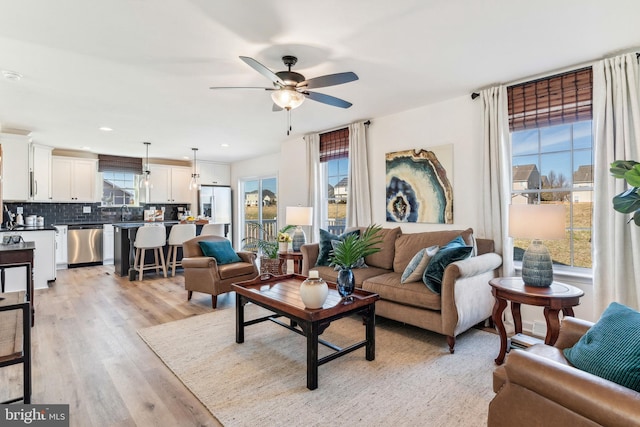 living room with ceiling fan, recessed lighting, and light wood-style floors
