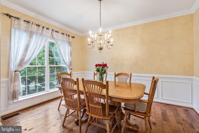 9804 Luck Penny Ct, Bristow, VA 20136 - dining space featuring a chandelier, hardwood / wood-style flooring, crown molding, a wainscoted wall, and a decorative wall