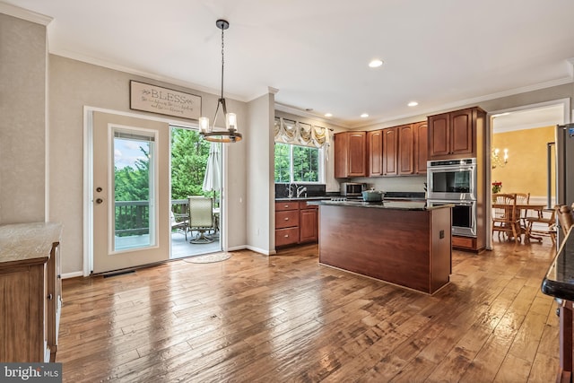 9804 Luck Penny Ct, Bristow, VA 20136 - kitchen with stainless steel double oven, a chandelier, hardwood / wood-style flooring, ornamental molding, and a center island