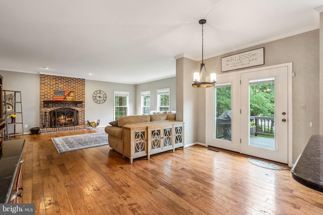 9804 Luck Penny Ct, Bristow, VA 20136 - living room featuring hardwood / wood-style flooring, crown molding, a chandelier, a fireplace, and baseboards