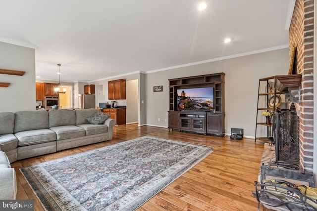 9804 Luck Penny Ct, Bristow, VA 20136 - living room featuring crown molding, light wood-style flooring, a fireplace, baseboards, and recessed lighting