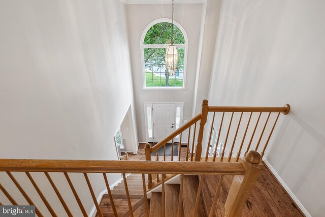 9804 Luck Penny Ct, Bristow, VA 20136 - staircase featuring wood finished floors, baseboards, and a chandelier