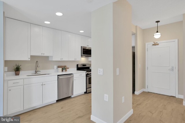 3600 S Glebe Rd Unit 321W, Arlington, VA 22202 - kitchen with stainless steel appliances, a sink, light wood-style flooring, white cabinetry, and recessed lighting