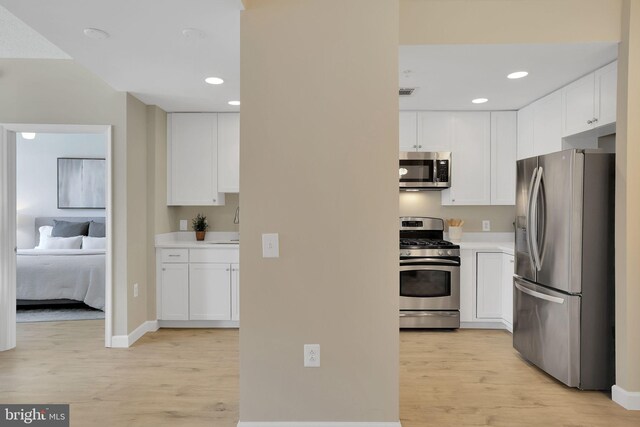 3600 S Glebe Rd Unit 321W, Arlington, VA 22202 - kitchen with appliances with stainless steel finishes, light wood-style flooring, white cabinetry, light countertops, and recessed lighting