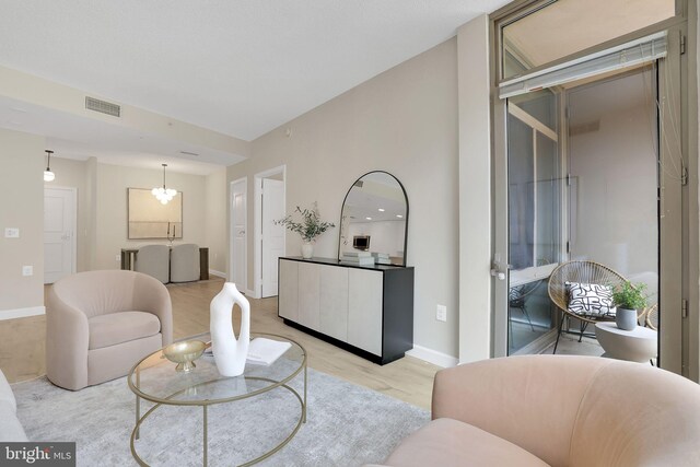 3600 S Glebe Rd Unit 321W, Arlington, VA 22202 - living room featuring light wood finished floors, a chandelier, and baseboards