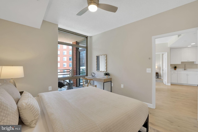 3600 S Glebe Rd Unit 321W, Arlington, VA 22202 - bedroom with floor to ceiling windows, a sink, light wood-style floors, and baseboards