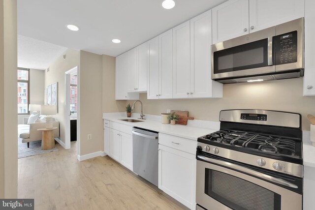3600 S Glebe Rd Unit 321W, Arlington, VA 22202 - kitchen with stainless steel appliances, light wood-style flooring, white cabinetry, baseboards, and recessed lighting