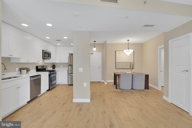 3600 S Glebe Rd Unit 321W, Arlington, VA 22202 - kitchen with stainless steel appliances, a sink, white cabinetry, light wood finished floors, and baseboards