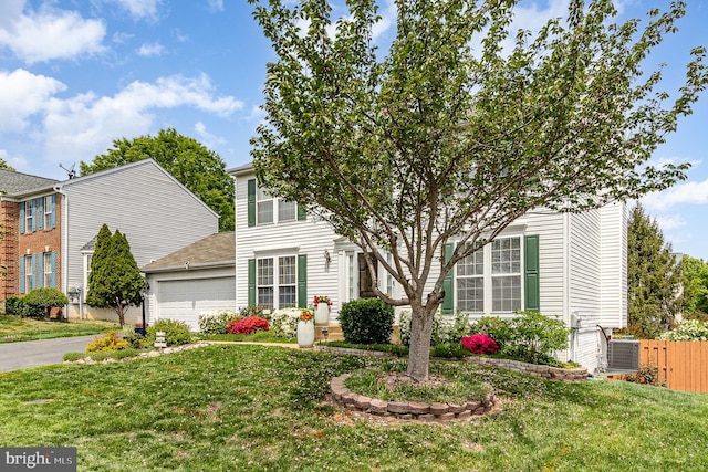 view of front of home with a front lawn, a garage, central AC unit, driveway, and fence