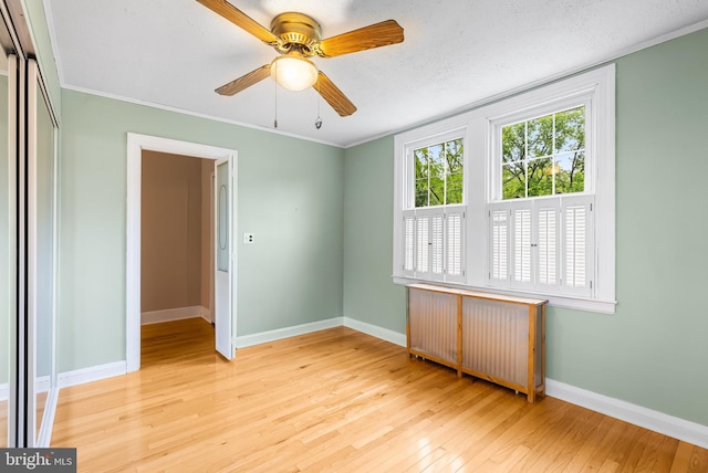 1822 Clearwood Rd, Baltimore, MD 21234 - empty room featuring radiator heating unit, wood-type flooring, baseboards, a ceiling fan, and crown molding