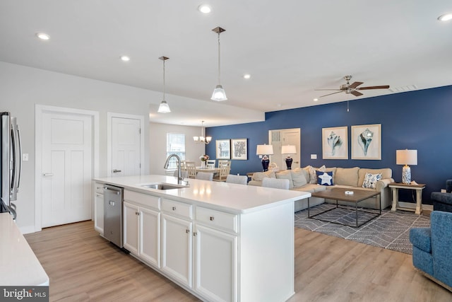 kitchen featuring white cabinetry, appliances with stainless steel finishes, a sink, and light wood finished floors