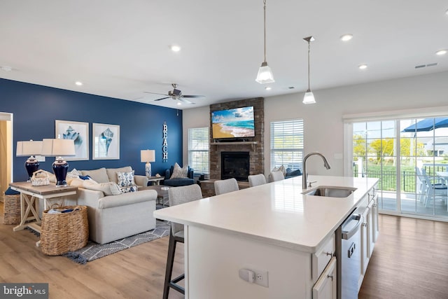 kitchen with white cabinets, a sink, light wood-style floors, light countertops, and visible vents