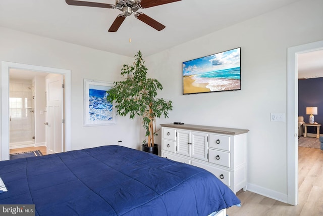 bedroom with connected bathroom, a ceiling fan, baseboards, and light wood-style floors