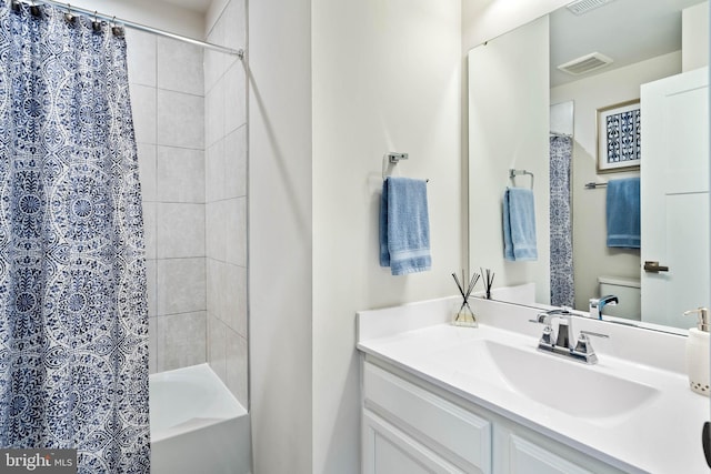 full bathroom featuring visible vents, shower / bath combo with shower curtain, toilet, and vanity
