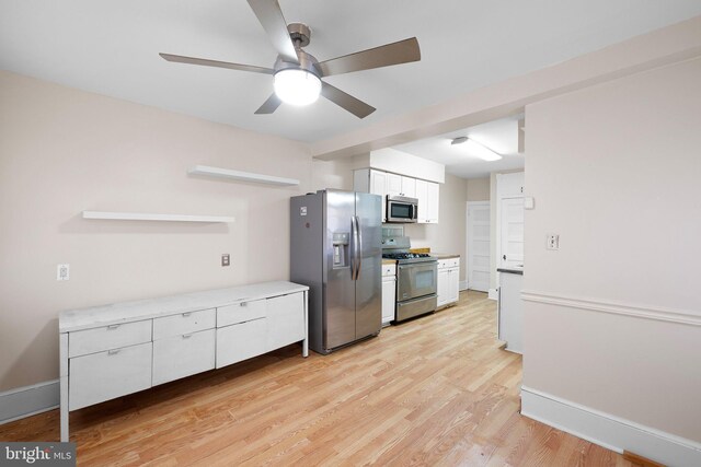 kitchen featuring stainless steel appliances, light countertops, ceiling fan, light wood finished floors, and white cabinetry