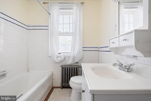 bathroom featuring tile walls, vanity, toilet, and radiator