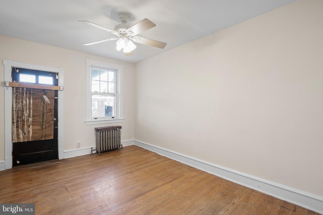 entryway featuring radiator heating unit, wood finished floors, a ceiling fan, and baseboards