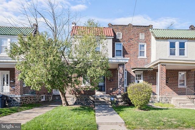 view of front of property with a front yard and brick siding