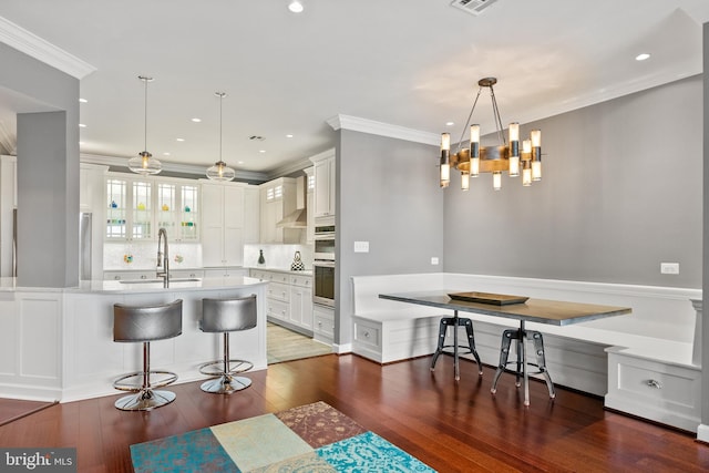 525 Belmont Bay Dr Unit 405, Woodbridge, VA 22191 - kitchen featuring a sink, hardwood / wood-style floors, ornamental molding, a breakfast bar area, and light countertops