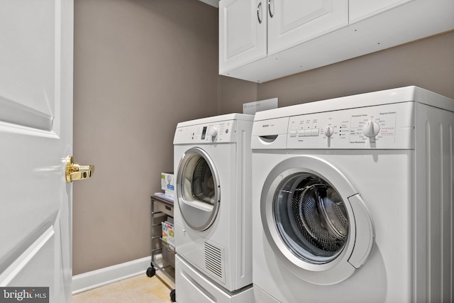 525 Belmont Bay Dr Unit 405, Woodbridge, VA 22191 - laundry area with cabinet space, washing machine and clothes dryer, light tile patterned floors, and baseboards