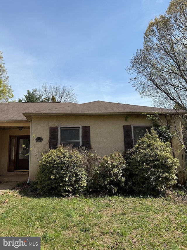 view of home's exterior featuring stucco siding and a yard