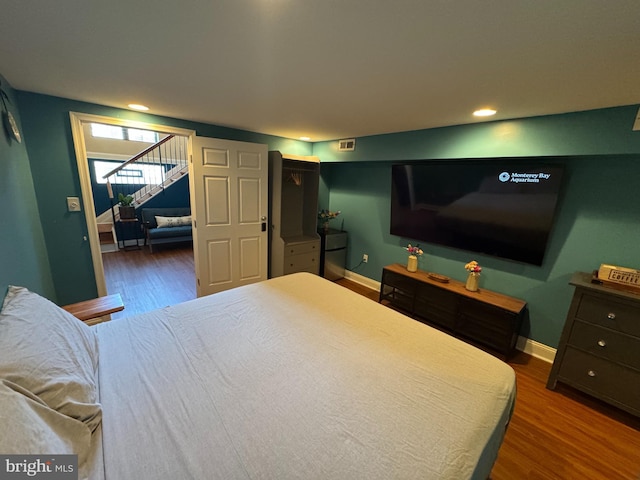 bedroom featuring baseboards, visible vents, and wood finished floors