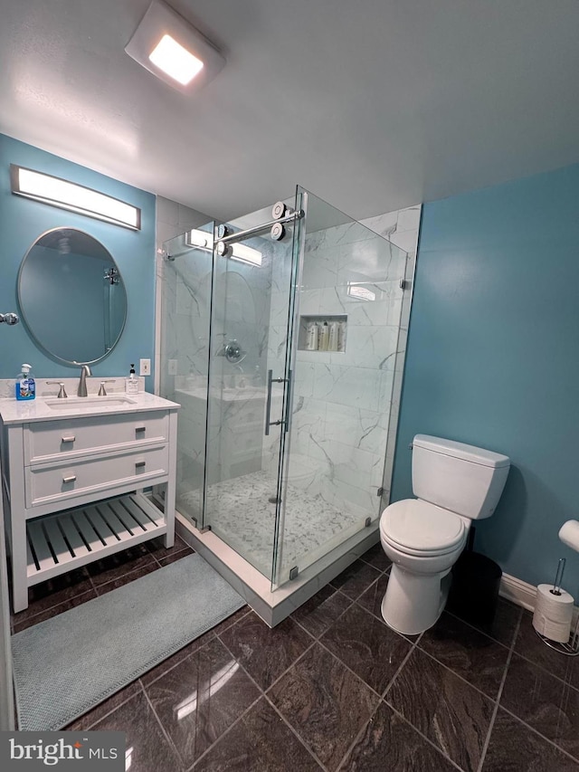 full bath with vanity, marble finish floor, toilet, baseboards, and a marble finish shower