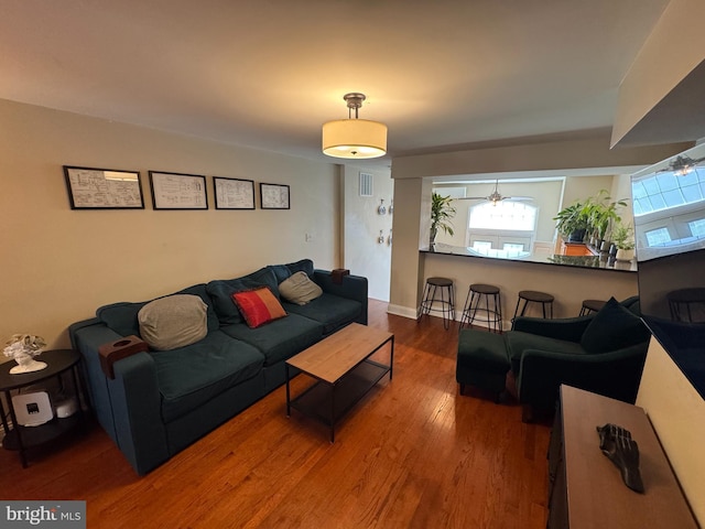 living room with baseboards, wood finished floors, and visible vents