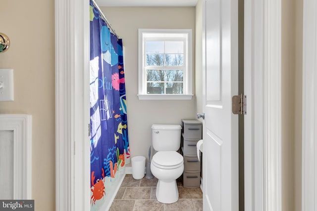 full bathroom featuring toilet, a shower with shower curtain, tile patterned floors, and baseboards