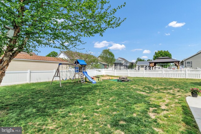 view of yard featuring a gazebo, a fenced backyard, and a playground