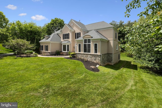 1418 Woodhurst Blvd, Mclean, VA 22102 - traditional-style home with stucco siding, stone siding, a front lawn, and roof with shingles