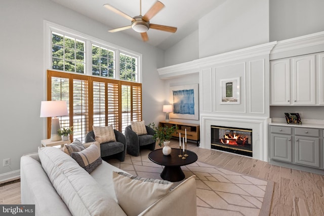 1418 Woodhurst Blvd, Mclean, VA 22102 - living room featuring a ceiling fan, high vaulted ceiling, a glass covered fireplace, and light wood finished floors