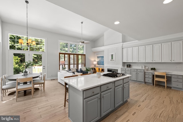 1418 Woodhurst Blvd, Mclean, VA 22102 - kitchen featuring gray cabinets, stainless steel gas stovetop, light countertops, a center island, and light wood-style flooring