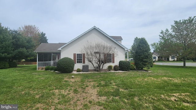 exterior space featuring a lawn, central AC, and a sunroom