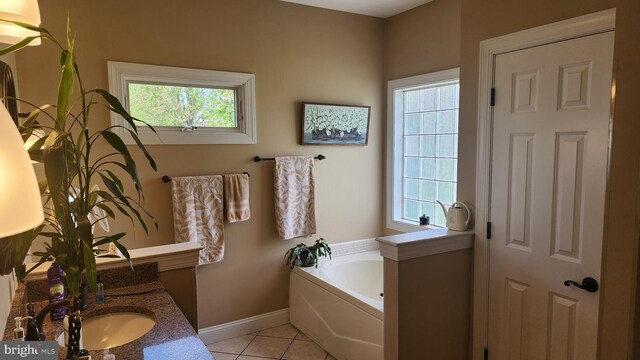 full bath with baseboards, tile patterned flooring, a bath, and vanity