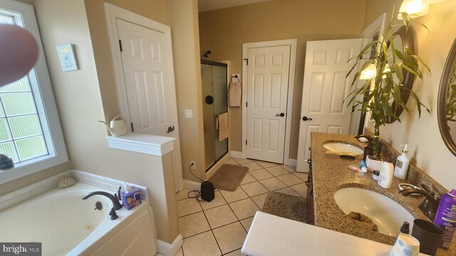 bathroom featuring tile patterned floors, a garden tub, a shower stall, and a sink