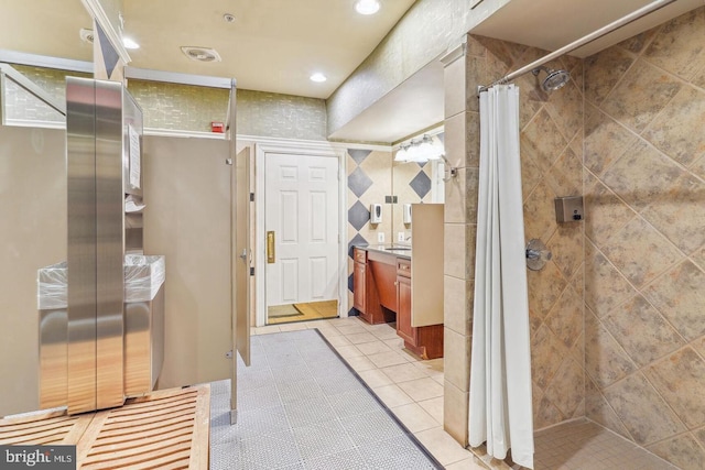 bathroom featuring tile patterned floors, recessed lighting, tiled shower, and vanity