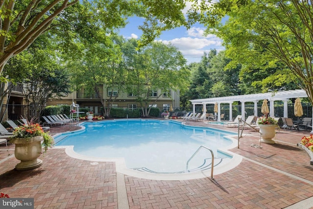 pool with a pergola, a patio, and fence