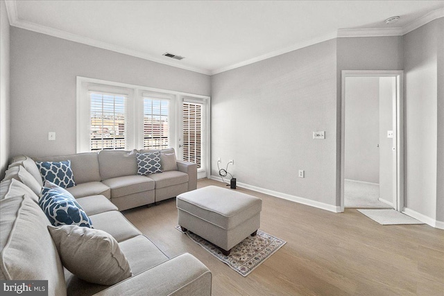living room featuring baseboards, visible vents, wood finished floors, and ornamental molding