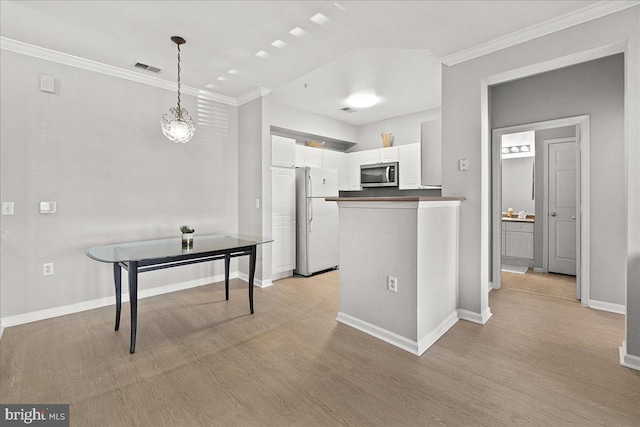 kitchen with stainless steel microwave, baseboards, freestanding refrigerator, and light wood-style floors